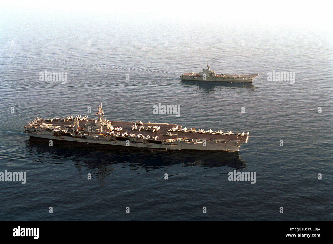 Il Thai Royal Naval nave HTMS CHAKRI NARUEBET (CVH 911), un elicottero carrier, operanti lungo il lato del USS Kitty Hawk (CV 63). Foto Stock