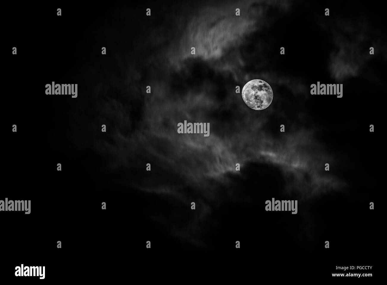 Luna piena nel mezzo di nuvole Foto Stock