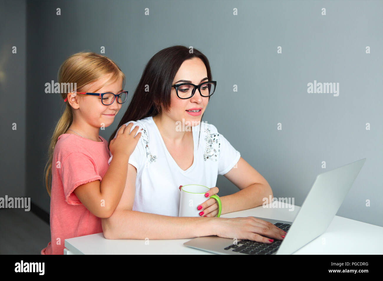 Madre impegnata a lavorare da casa con la figlia piccola Foto Stock