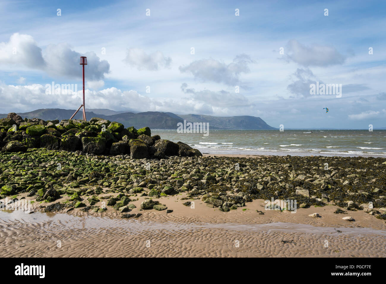 La sponda occidentale spiaggia di Llandudno sulla costa del Galles del Nord. Vista sulle colline lungo la costa su una soleggiata giornata di primavera. Foto Stock