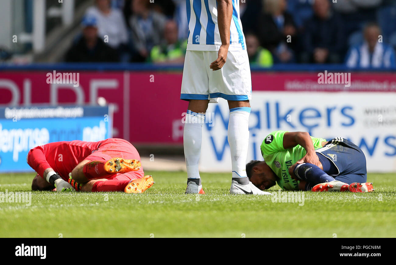 L Huddersfield Town portiere Ben Hamer (sinistra) e Cardiff City's Nathaniel Mendez-Laing (destra) sulla terra feriti dopo la collisione con ogni altro durante il match di Premier League a John Smith's Stadium, Huddersfield. Foto Stock