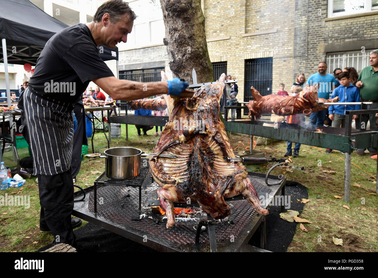 Londra, Regno Unito. Il 25 agosto 2018. Una pecora viene torrefatto utilizzando l'argentino asado la tecnica a Smithfield 150, una celebrazione del centocinquantesimo anniversario di Smithfield mercati di Farringdon. L'evento mette in mostra il meglio di Londra la vibrante cultura e la creatività attraverso la musica, cibo e intrattenimenti. Credito: Stephen Chung / Alamy Live News Foto Stock