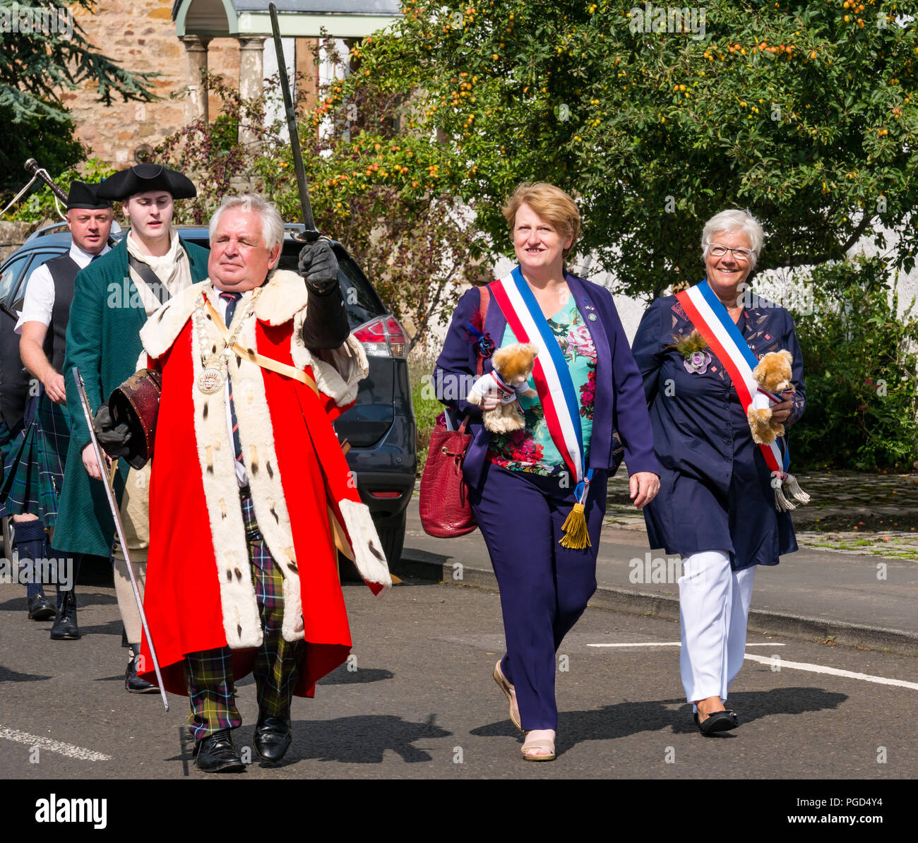 Haddington, Scotland, Regno Unito. Il 25 agosto 2018. Haddington 700 medievale celebrazioni grande giornata Giornata medievale è il momento clou di Haddington 700 gli eventi che avranno luogo nel 2018 per celebrare la concessione di una carta da Robert the Bruce alla città nel 1318. Eventi in tutta la città di mercato includono una parata. Il Prevosto di East Lothian, John McMillan, Scottish Assessore Lavoro vestiti in un ermellino robe conduce la parata attraverso la città con il sindaco e vice sindaco di Aubigny-sur-nere, Haddington gemella di città in Francia Foto Stock