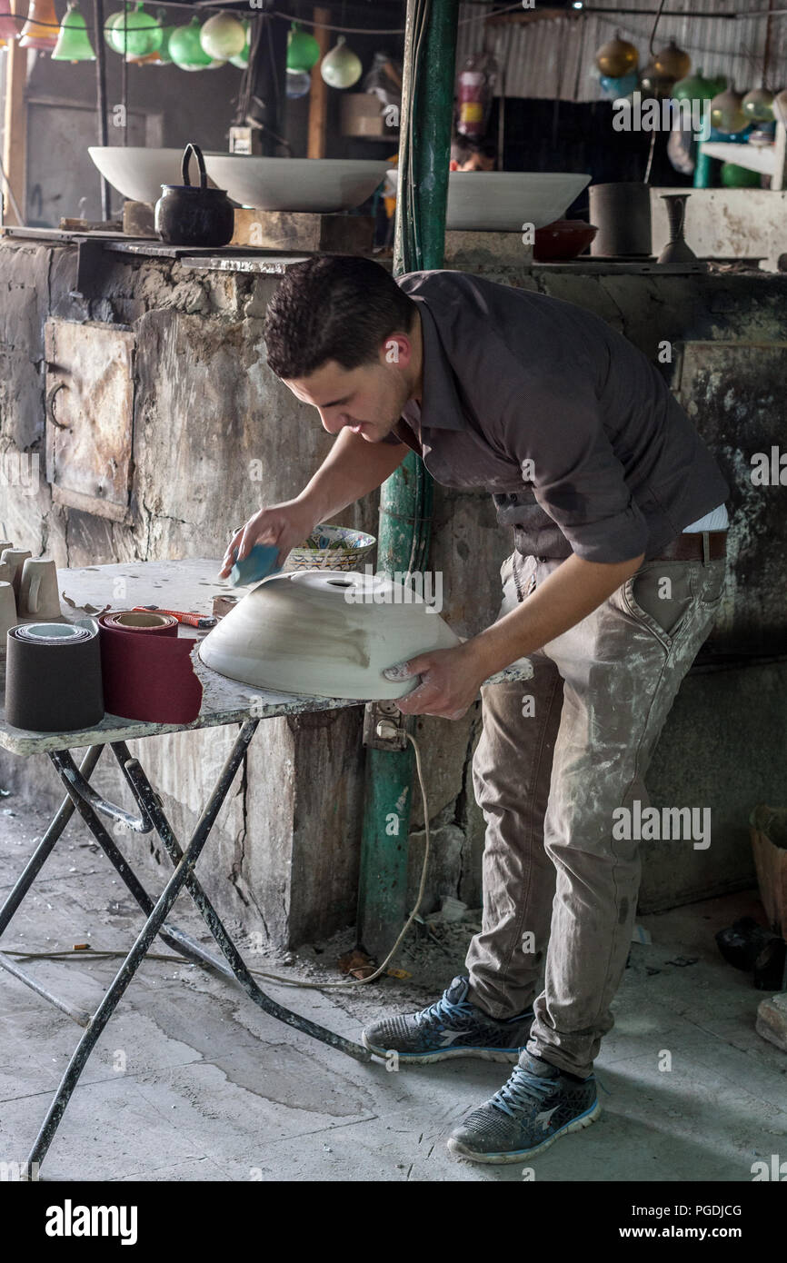 Hebron, Palestina, Giugno 4, 2014: giovani palestinesi lavora in un laboratorio di argilla che produce utensili domestici. Foto Stock