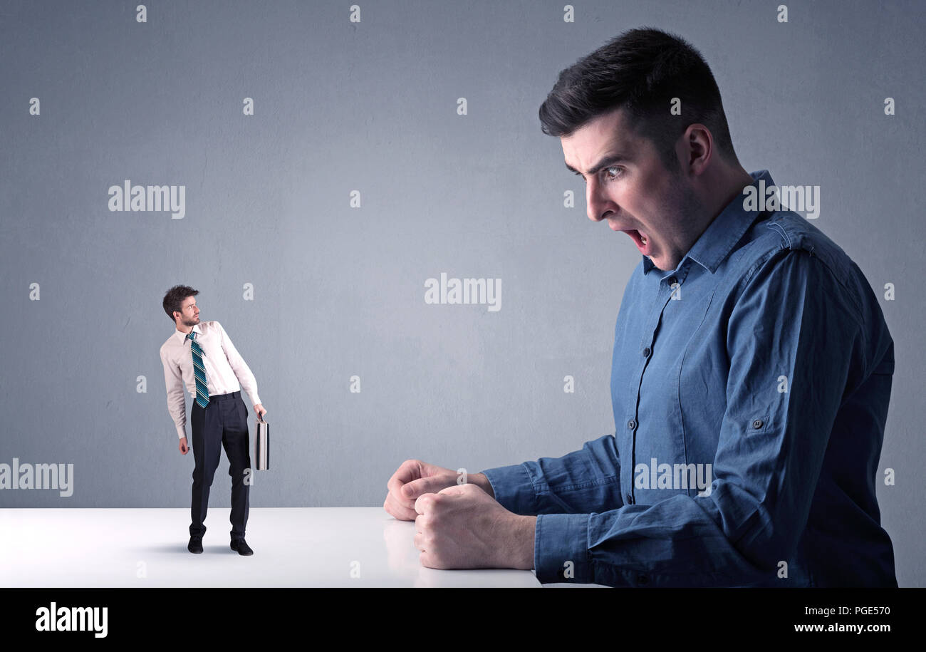 Giovane imprenditore professionale essendo arrabbiato con un altro imprenditore in miniatura Foto Stock
