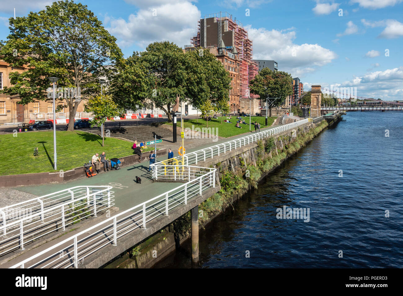 Per coloro che godono di una posizione soleggiata, verso la fine di agosto pomeriggio tra il Clyde camminamento e Clyde Street vicino alla S. Portland St sospensione ponte di Glasgow, Scozia Foto Stock