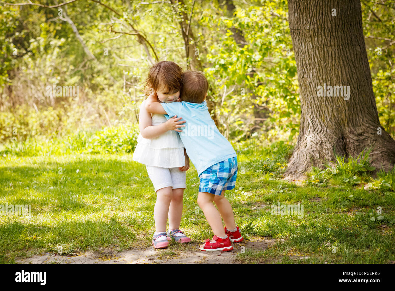 Ritratto di due simpatici adorabili bambini Bambini Bimbi abbracciando e baciando ogni altro amore amicizia nel concetto di infanzia, migliori amici per sempre Foto Stock
