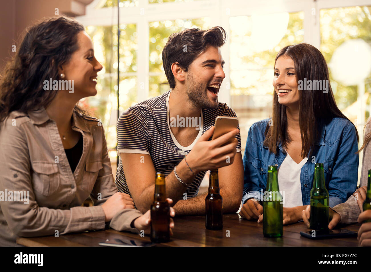 Un gruppo di amici al bar a bere una birra Foto Stock