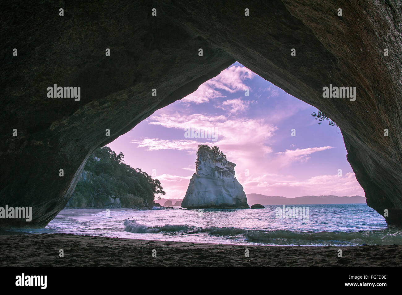 Tramonto, Cove della cattedrale, Penisola di Coromandel, Nuova Zelanda. Vista attraverso il rock arco verso Te Hoho Rock Foto Stock