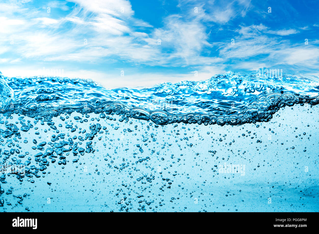 Molte bolle di aria in acqua vicino, astratto onda di acqua con bolle su uno sfondo di cielo blu Foto Stock