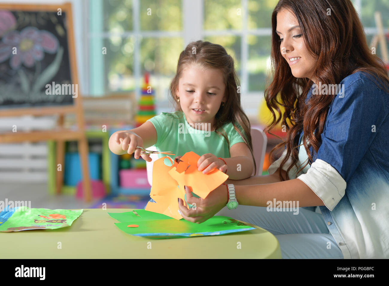 La Madre insegna kid per fare gli oggetti artigianali Foto Stock