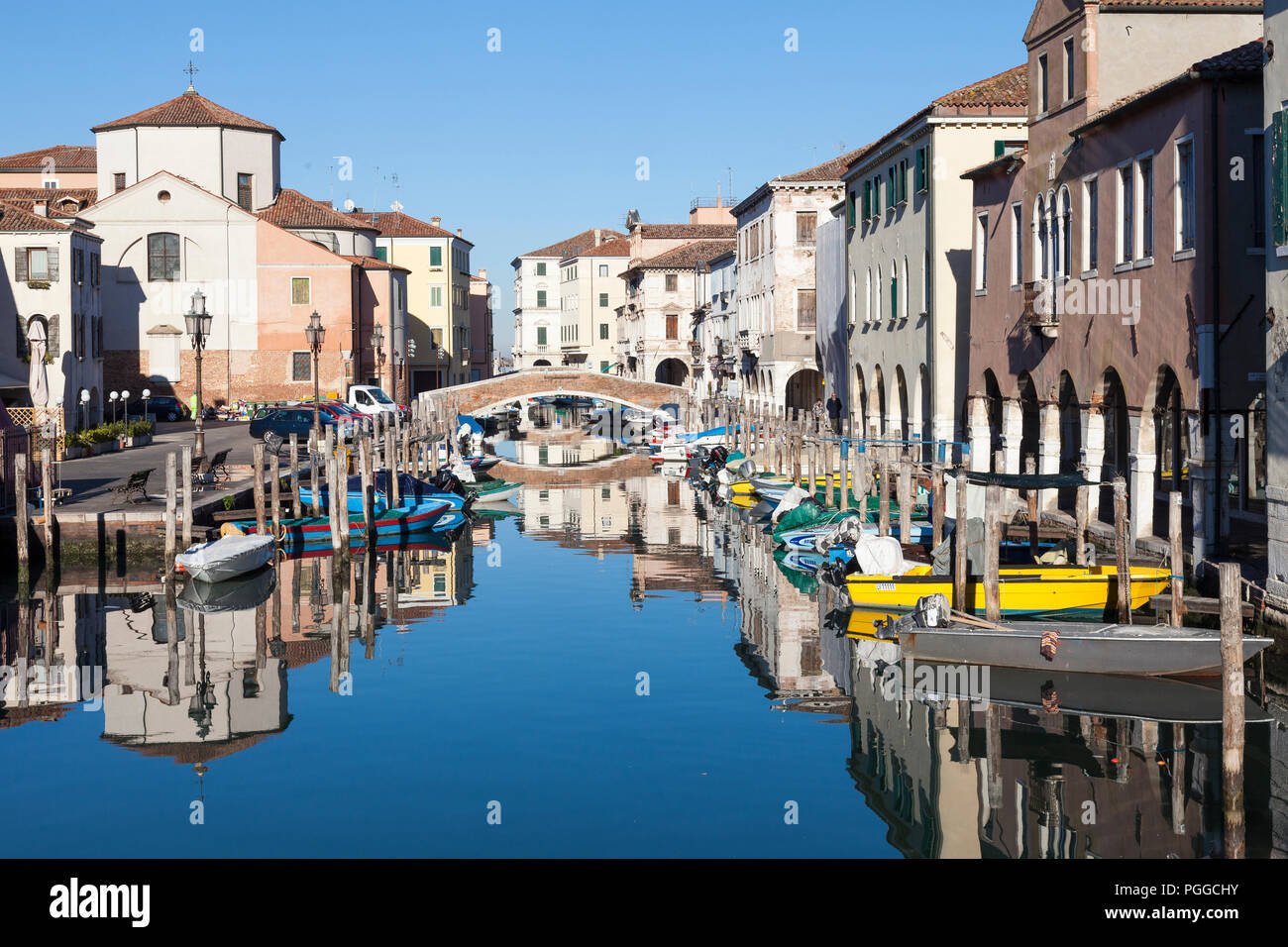 Chiesa San Andrea riflessa nella vena Canal, Chioggia, Venezia, Veneto, Italia su una tranquilla soleggiata giornata invernale in un suggestivo paesaggio urbano Foto Stock