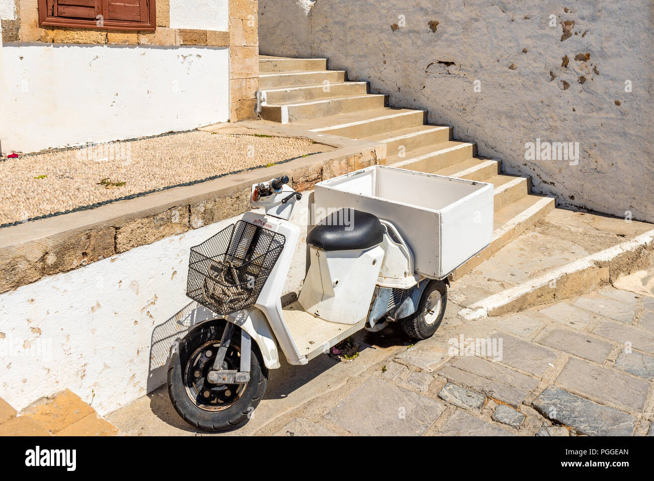 RHODES, Grecia - 14 Maggio 2018: tipico greco scooter parcheggiato sulla strada stretta di Lindos. L' isola di Rodi, Grecia Foto Stock