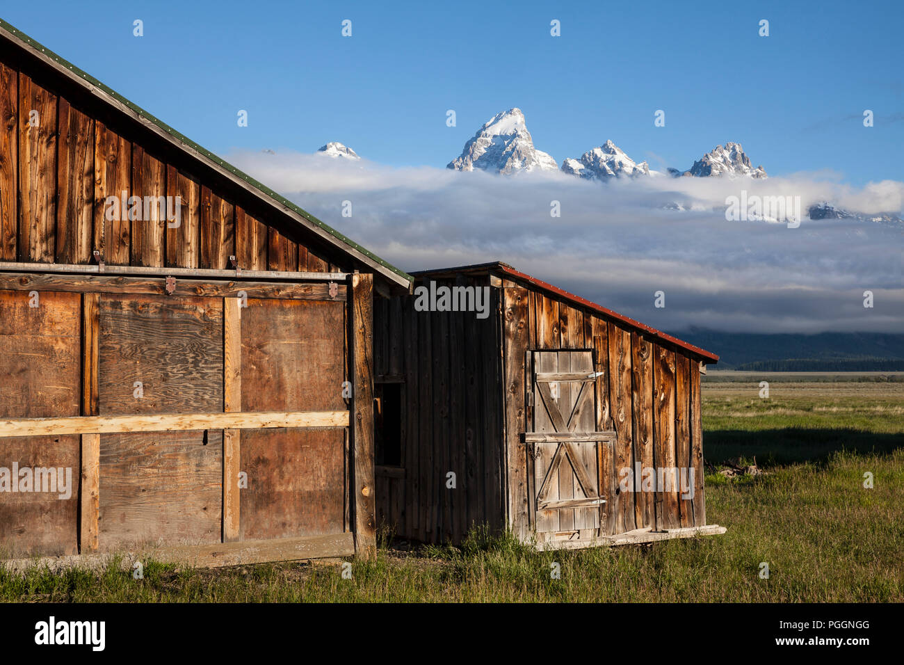 WY03256-00...WYOMING - storico fienile lungo il Mormon fila con la gamma Teton in distanza, il Parco Nazionale di Grand Teton. Foto Stock