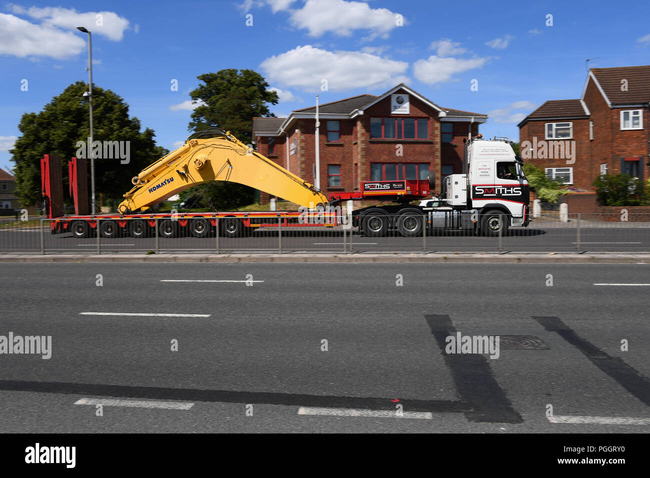 Un pezzo di pesanti macchinari di essere trasportati su un rimorchio a pianale ribassato sul modo di Southampton Docks. Foto Stock
