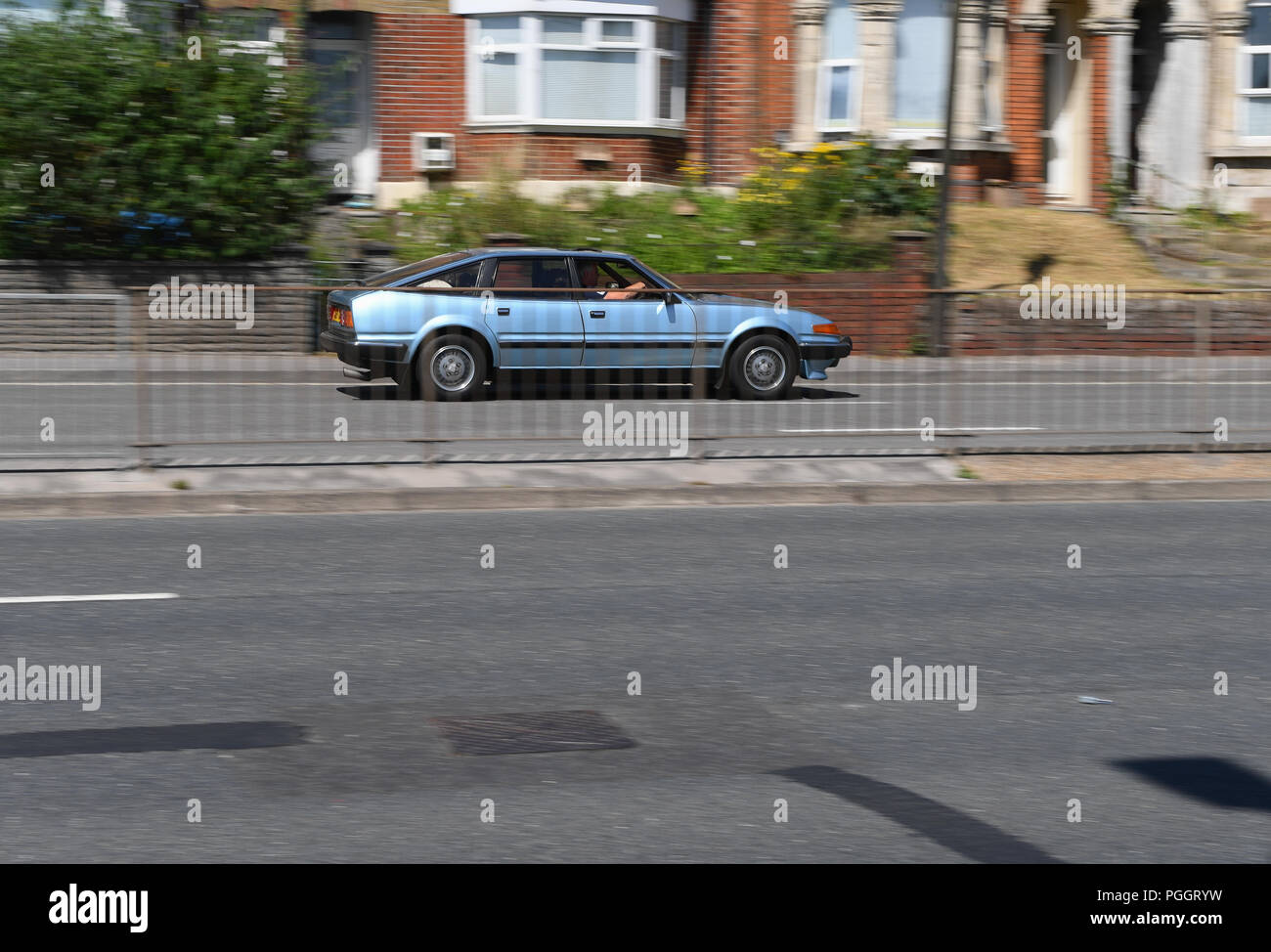Un classico azzurro British Leyland Rover Vitesse auto guidando lungo una duplice modo carrello. Foto Stock