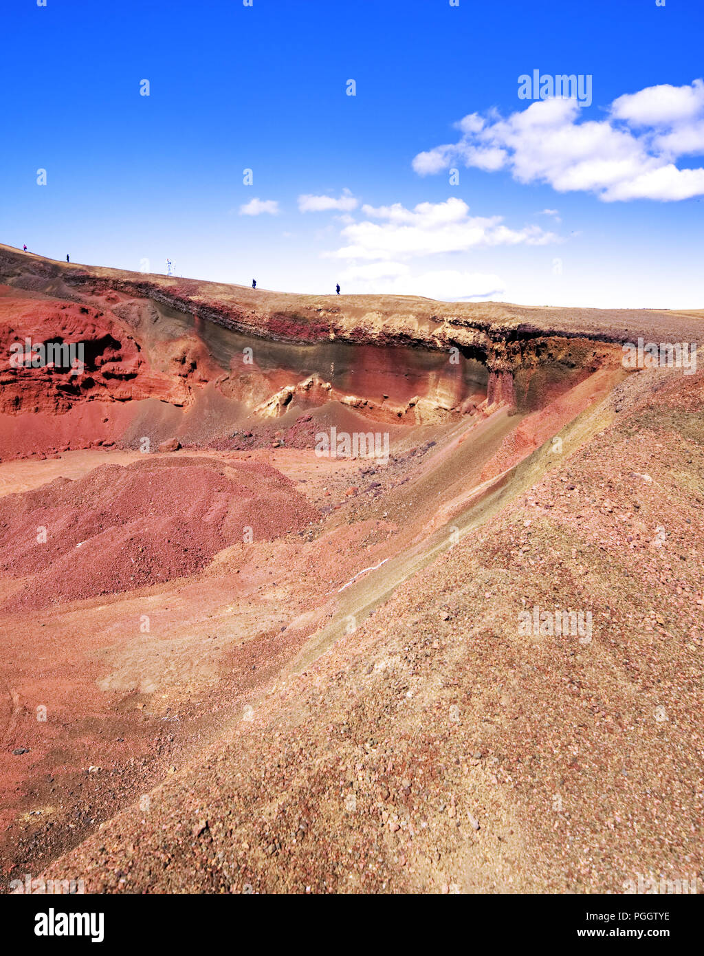 Ammira un cratere vulcanico rosso con i visitatori che camminano lungo il bordo dell'Islanda Foto Stock