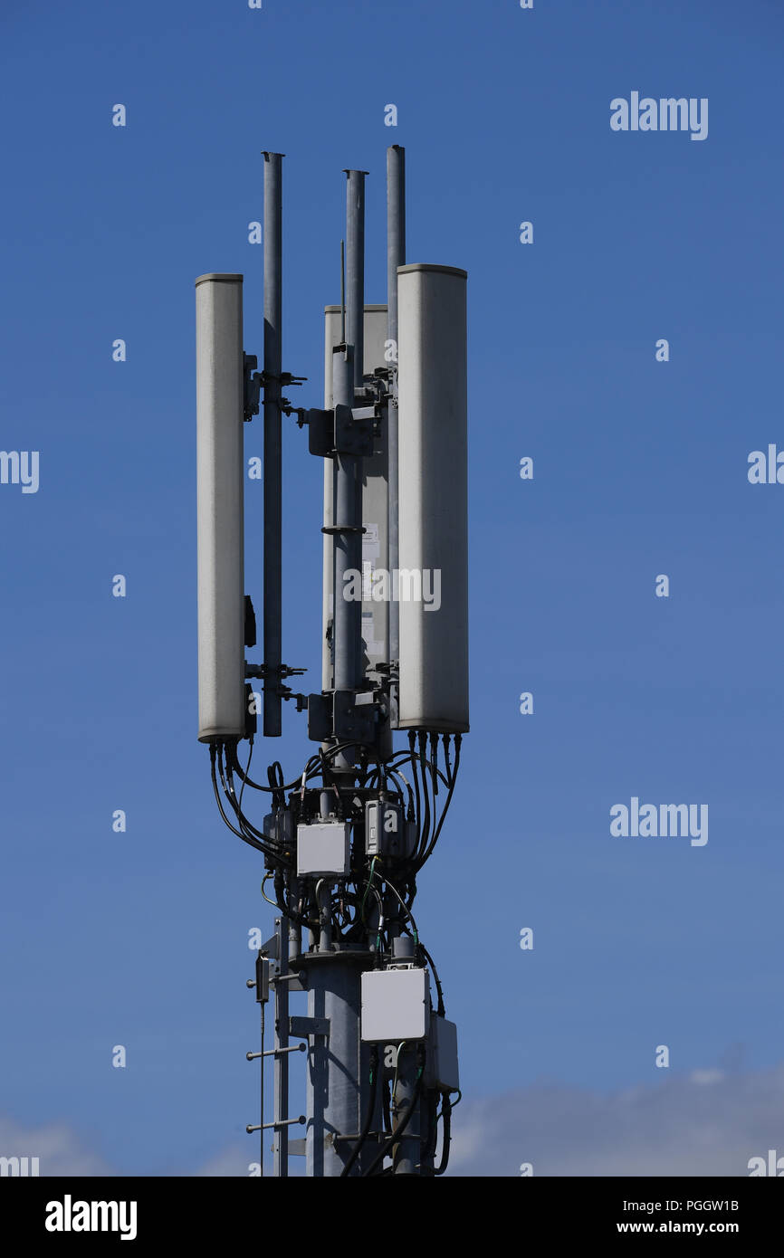Un close-up di un montante di comunicazione per il telefono e il segnale di dati contro un cielo blu Foto Stock