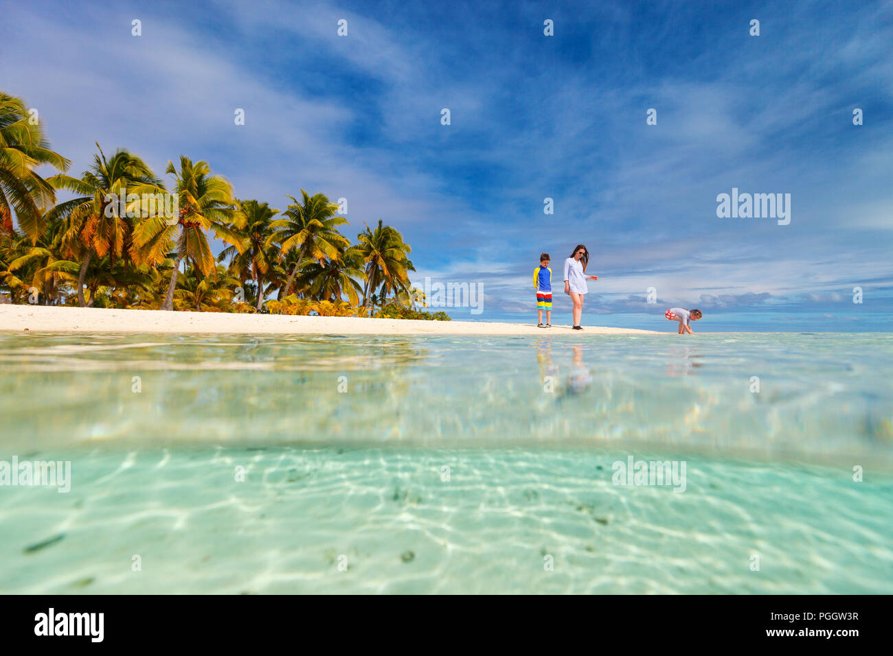 Madre e bambini e famiglia in spiaggia tropicale sull'isola di Aitutaki, Isole Cook, Sud Pacifico Foto Stock