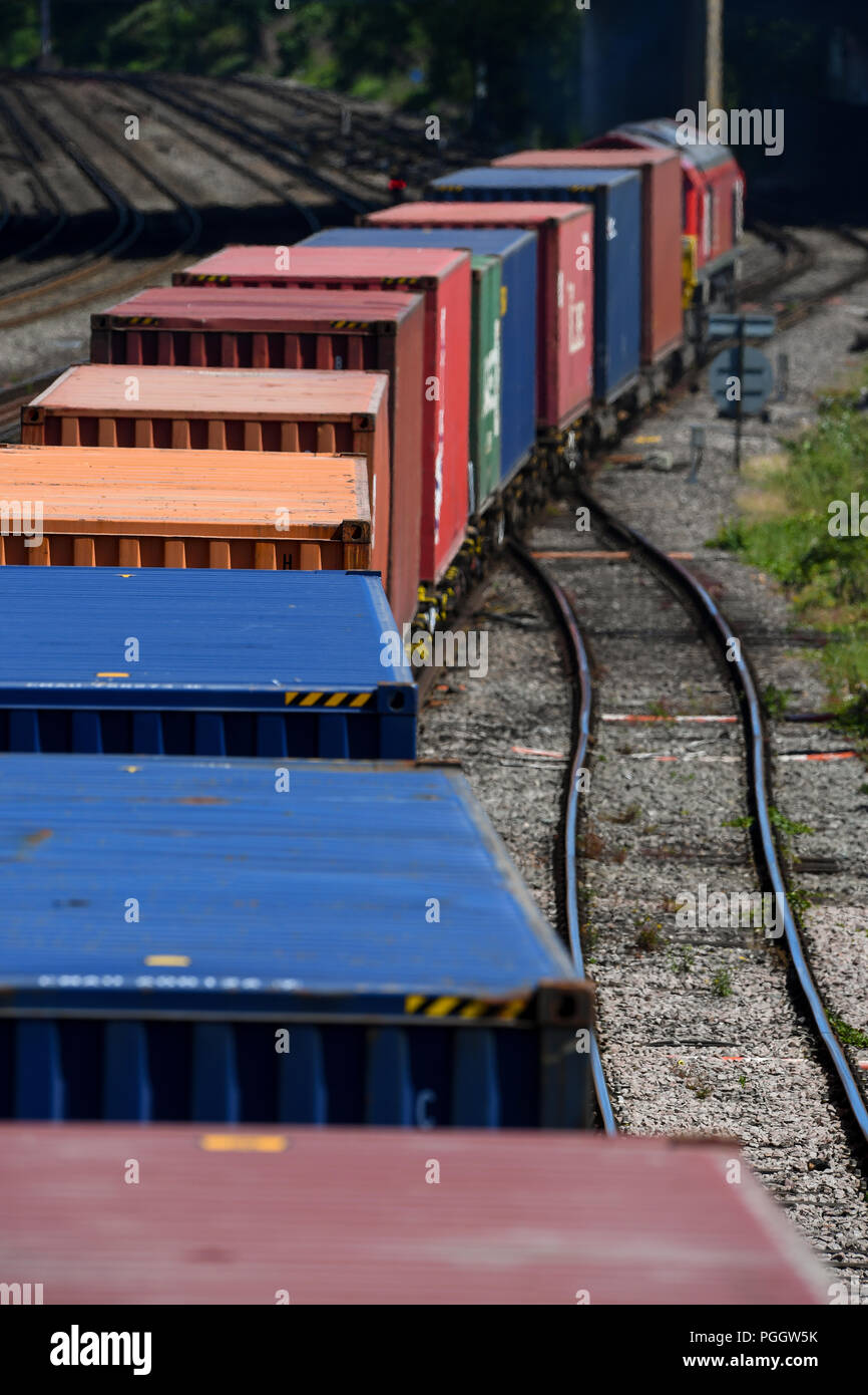 Contenitore convoglio ferroviario in viaggio sulla linea principale in Southampton e Southampton Docks carring merci per l'esportazione e importazione. Foto Stock