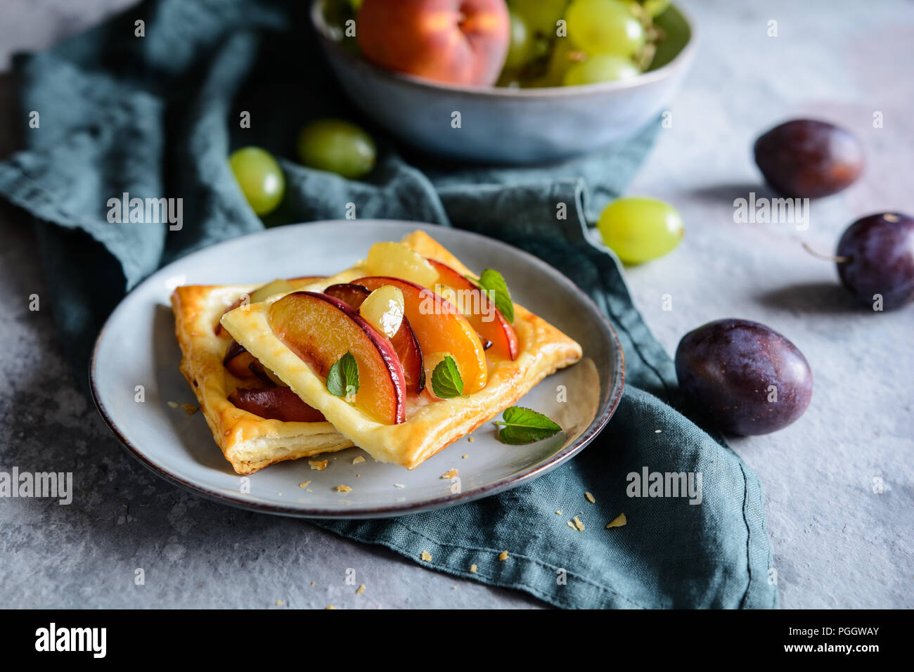 Frutto della pasta sfoglia torte con fette di pesche, susine e uva Foto Stock