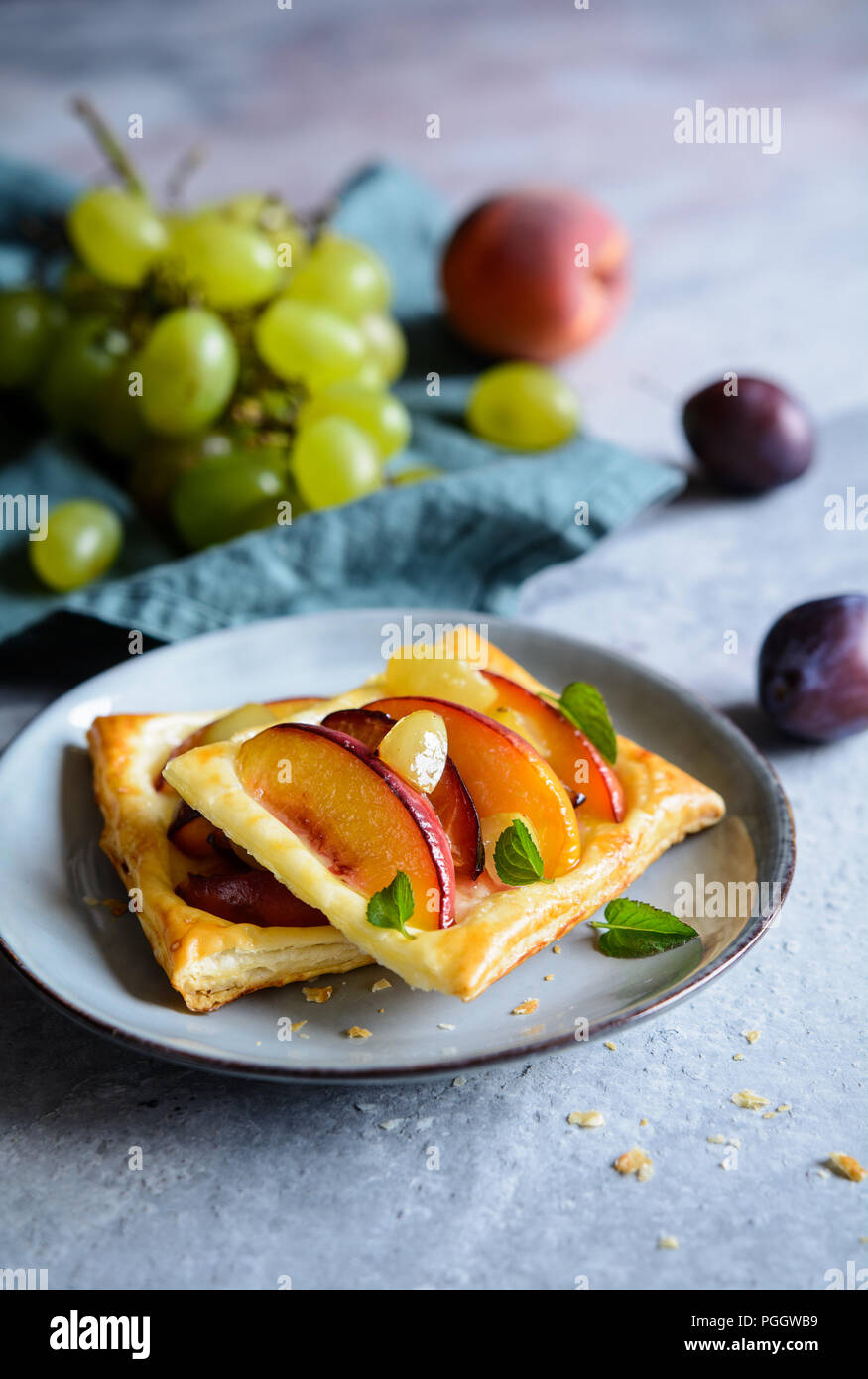 Frutto della pasta sfoglia torte con fette di pesche, susine e uva Foto Stock
