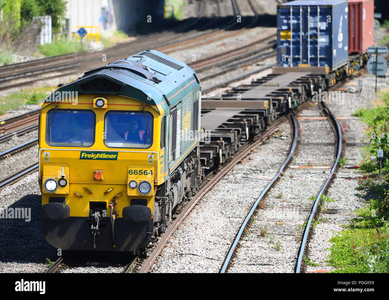 Contenitore convoglio ferroviario in viaggio sulla linea principale in Southampton e Southampton Docks carring merci per l'esportazione e importazione. Foto Stock