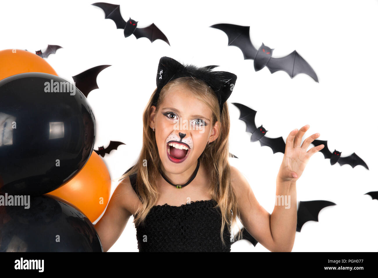 Sorridente Ragazza con gatto nero costume, Halloween trucco e arancio e nero palloncini a festa di Halloween, Pumpkin Patch. I bambini di Halloween. Foto Stock