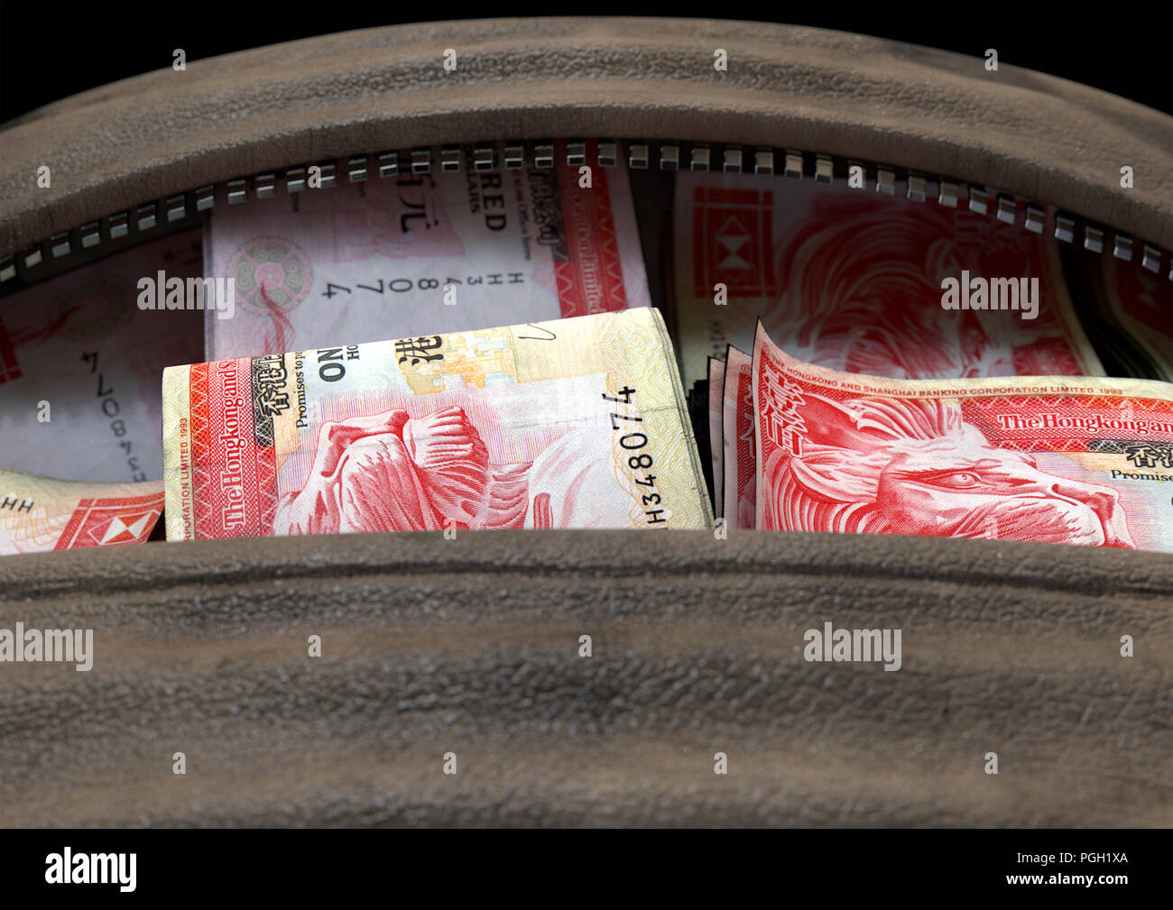 Un concetto di contrabbando che raffigura un aperto in pelle marrone borsone rivelando di fasci di laminati illecita dollaro di Hong kong note - 3D render Foto Stock