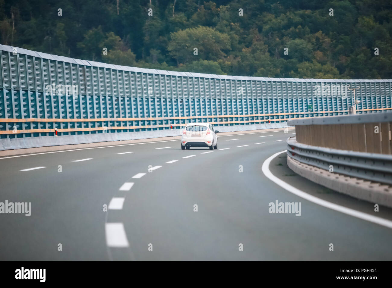 Vista posteriore della vettura la guida su autostrada con barriera di rumore. Foto Stock