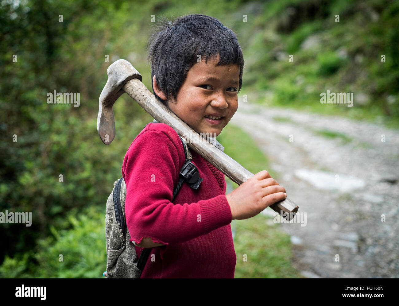 Agricoltore kid con la zappa a piedi a scuola in Landruk. Annapurna trek. Il Nepal Foto Stock