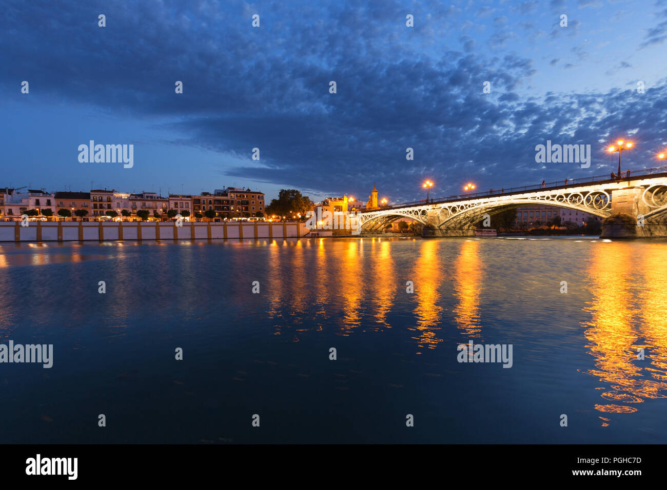 Siviglia di notte, Spagna / vista panoramica della città vecchia di un ponte storico Foto Stock