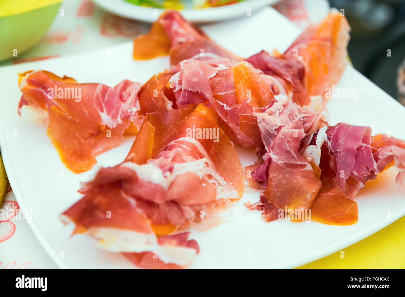 Prosciutto e melone - squisiti antipasti italiani nella piastra bianca sul tavolo Foto Stock