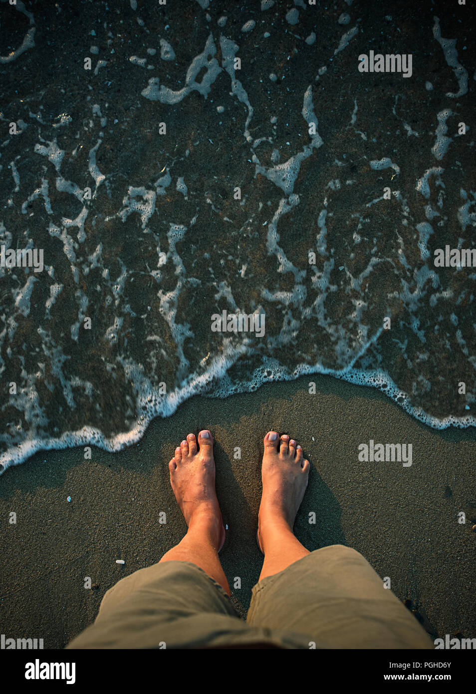 Colpo di Testa di uomo di piedi sulla spiaggia sabbiosa Foto Stock