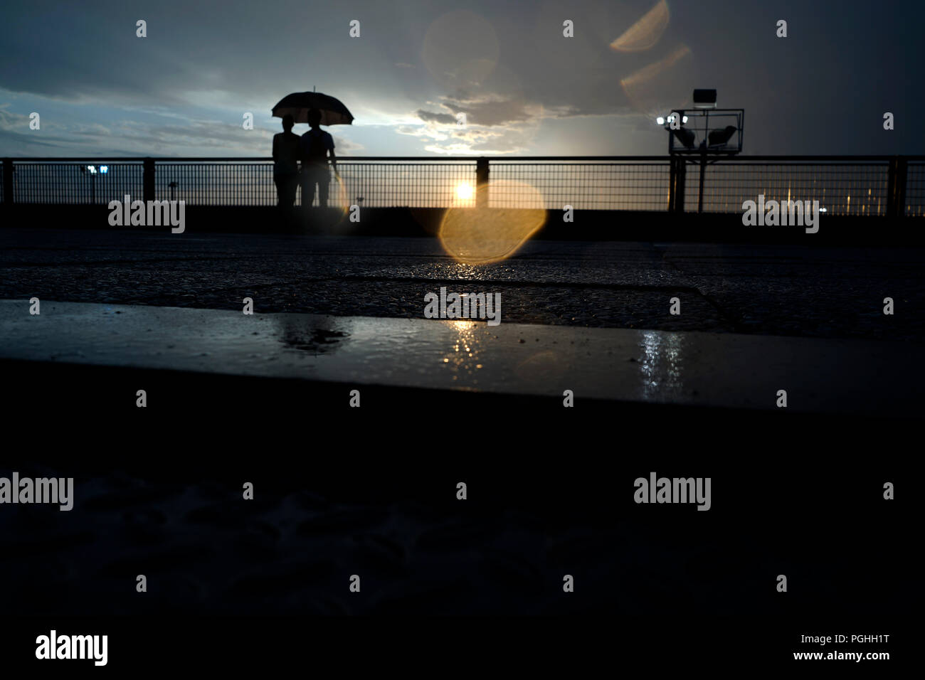 Un giovane su una pioggia tramonto Foto Stock