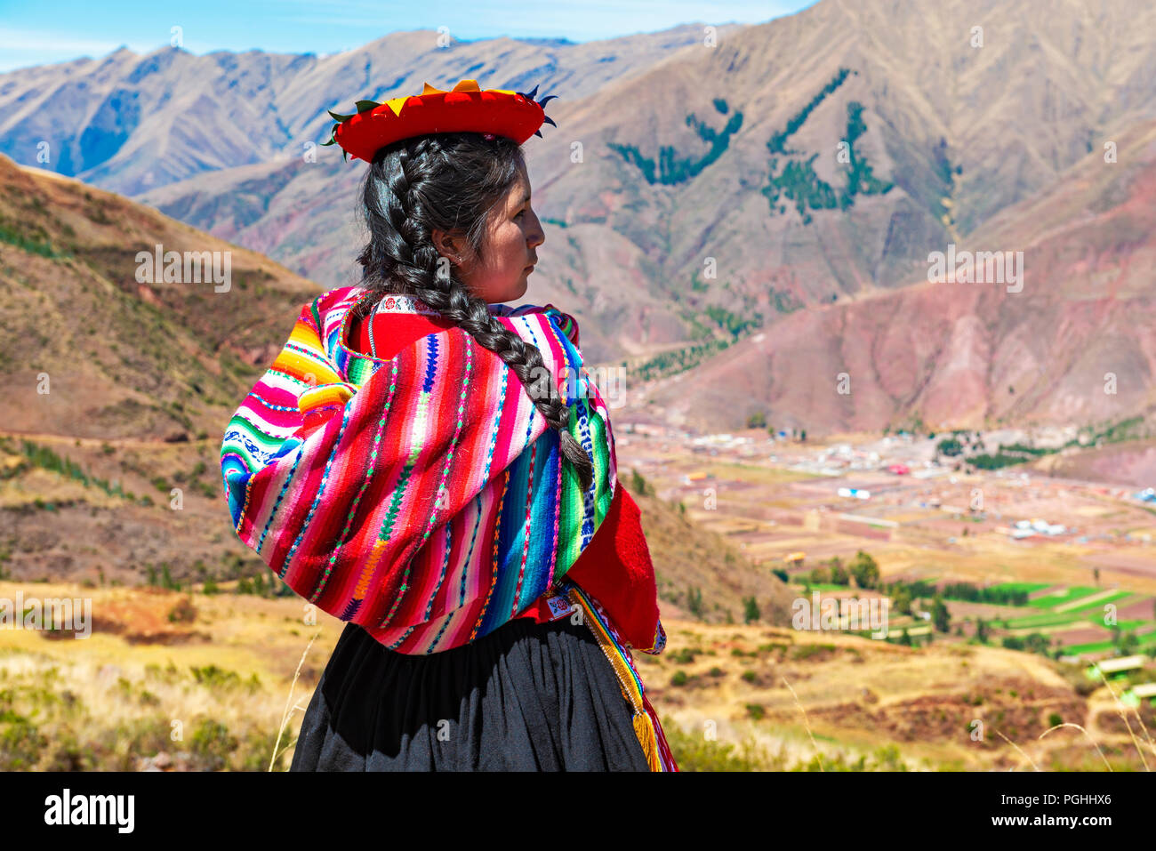 Giovani indigeni Quechua ragazza guardando la Valle Sacra degli Inca nella Cordigliera delle Ande in rovina Inca di Tipon vicino alla città di Cusco, Perù. Foto Stock