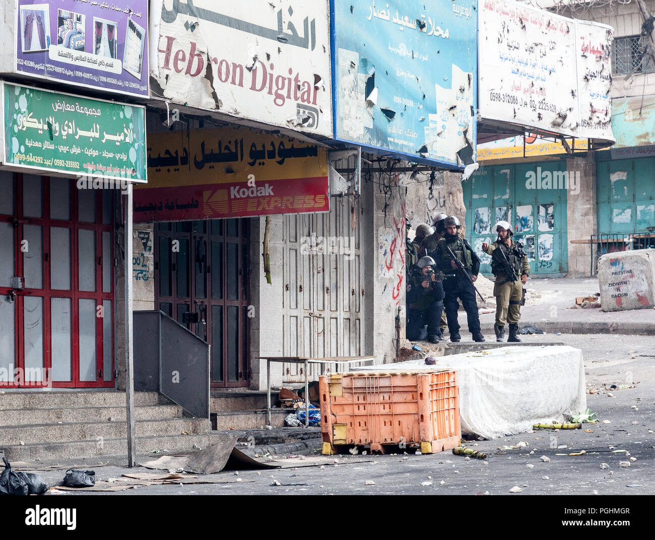 Hebron, Palestina, Novembre 29, 2013: Forze di Difesa Israeliane soldati si stanno muovendo in avanti attraverso le strade di spingere fuori i palestinesi durante i tumulti in Foto Stock