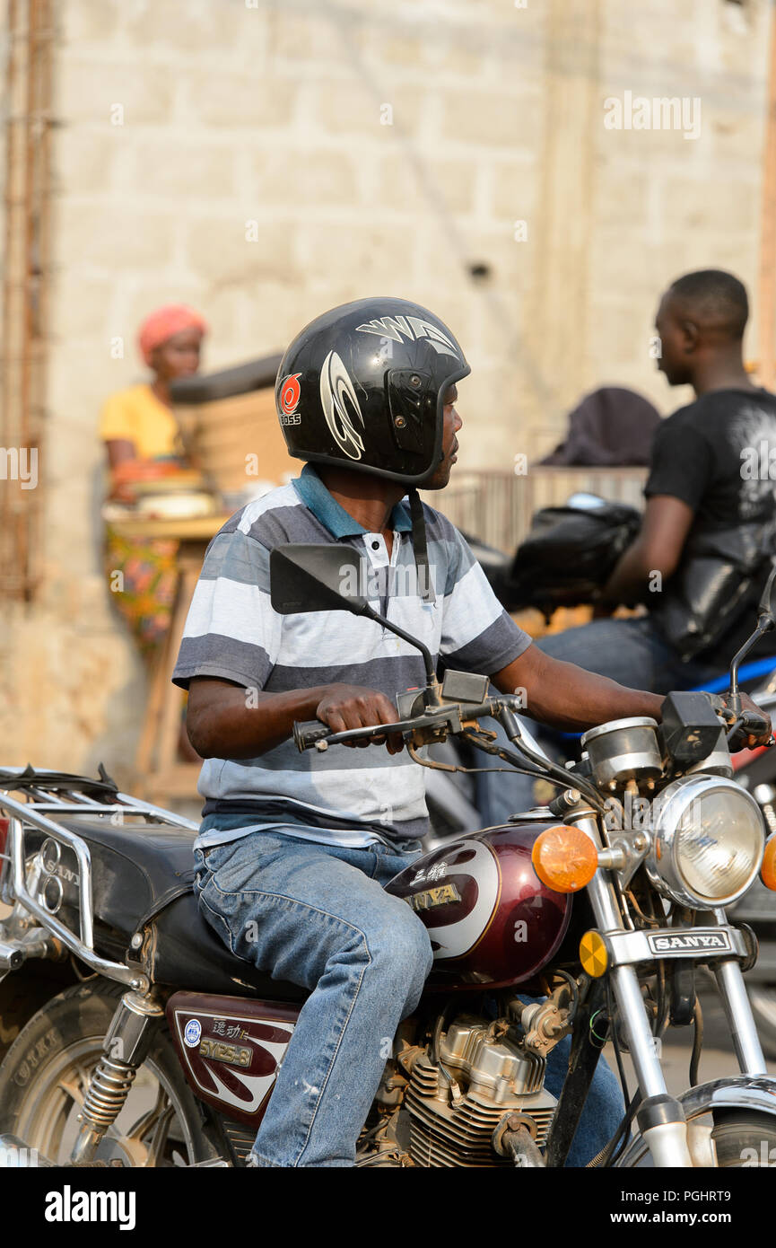 OUIDAH, BENIN - Jan 10, 2017: Beninese non identificato uomo cavalca un motociclo. Benin di persone soffrono di povertà a causa di una cattiva economia Foto Stock