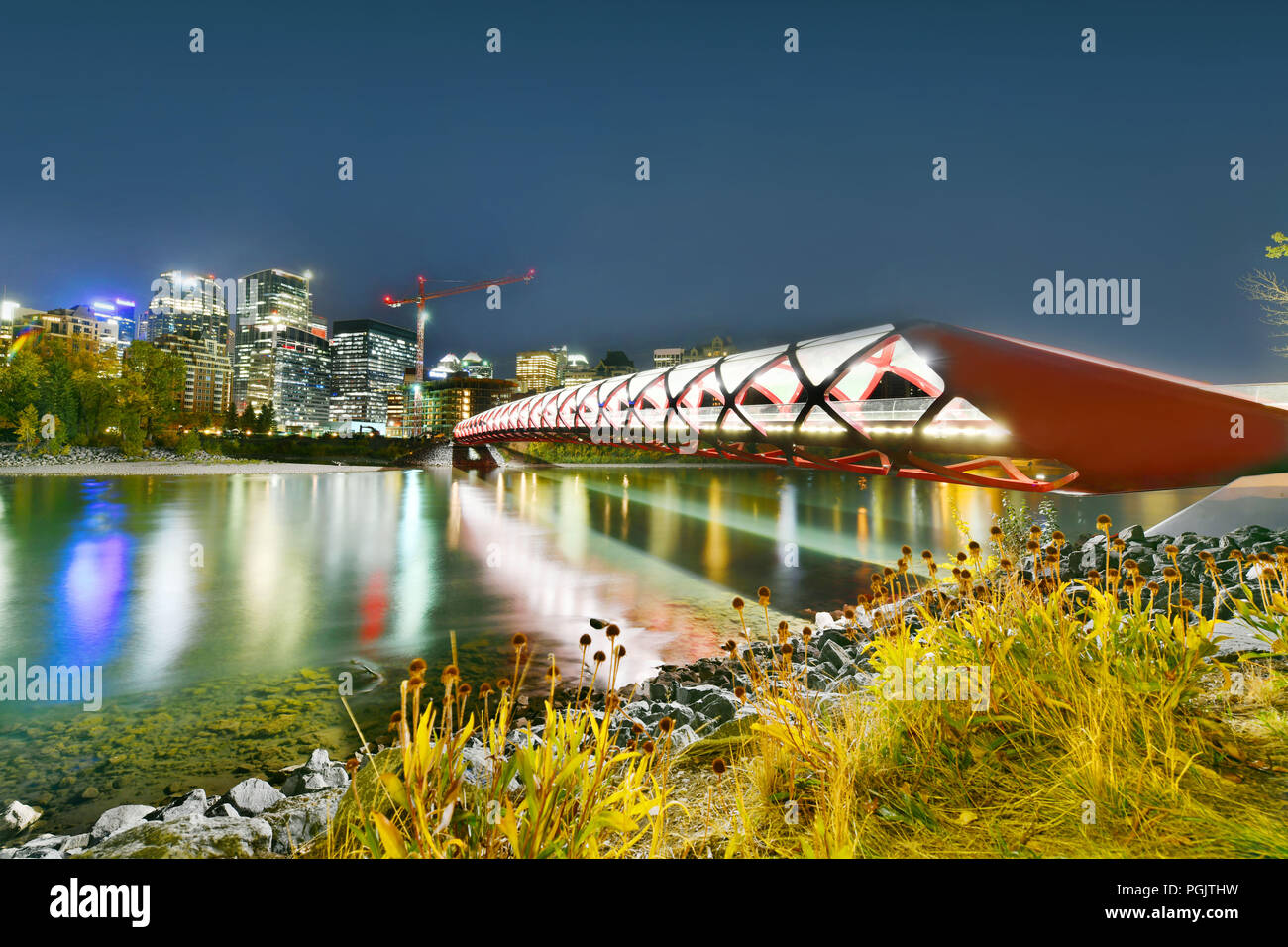 Ponte di pace con il Fiume Bow e parte del centro cittadino di Calgary in Alberta Canada di notte Foto Stock