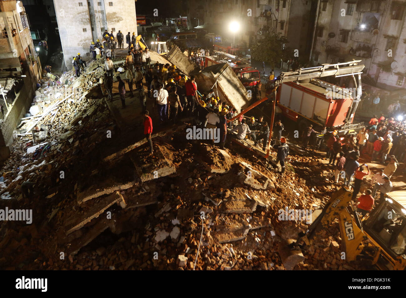 Ahmedabad, India. 26 Ago, 2018. Soccorritori lavoro presso il sito di un edificio crollato in Ahmadabad, Gujarat, India, e il agosto 26, 2018. Almeno 10 persone sono state temuto intrappolato sotto le macerie a seguito del crollo di un edificio a quattro piani di domenica in western lo stato indiano del Gujarat, la polizia ha detto. Credito: Stringer/Xinhua/Alamy Live News Foto Stock