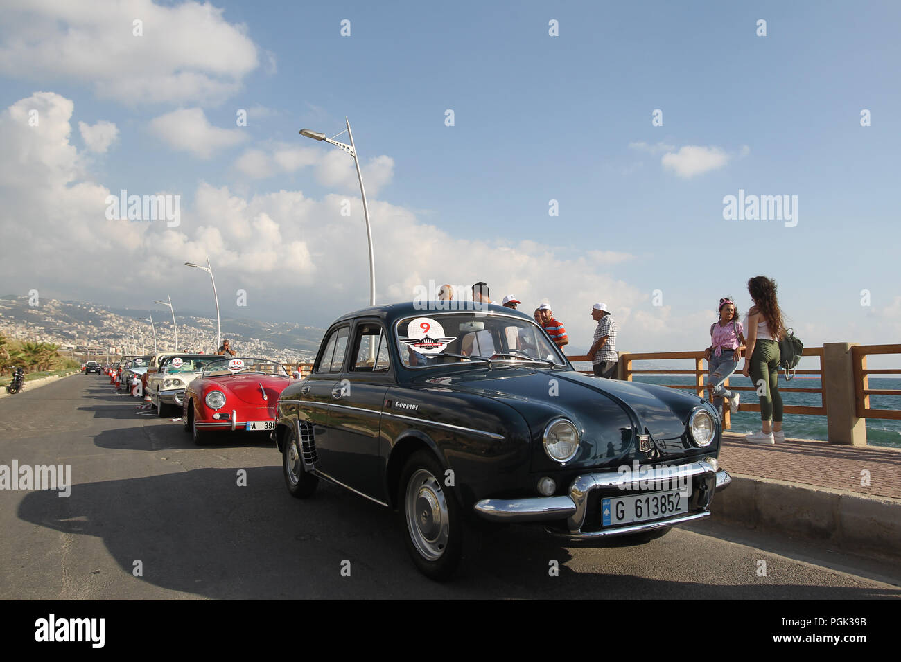 Beirut, Lebannon. 26 Ago, 2018. La gente guarda la collezione Classic Cars Parade 2018 presso il villaggio di Amchit, a nord di Beirut, Lebannon, su agosto 26, 2018. Più di 60 automobili classiche databile fra gli anni quaranta e la fine degli anni settanta ha sfilato per il quinto anno consecutivo qui di domenica. Credito: Bilal Jawich/Xinhua/Alamy Live News Foto Stock