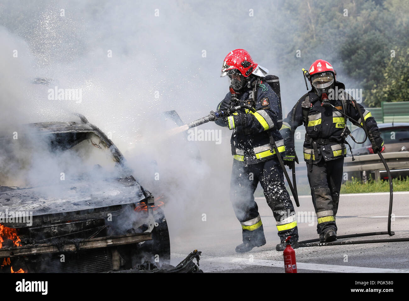 Gdynia, Polonia 27th. Agosto 2018 macchina fuoco sulla S6 - TriCity ringroad a Gdynia. Vigili del fuoco da dello Stato polacco Vigili del Fuoco (Straz Pozarna) sono visibili mentre tenta di controll fire della Renault New Scenic 5 posti auto. Vettura ha cominciato a bruciare violentemente durante la guida. © Vadim Pacajev / Alamy Live News Foto Stock