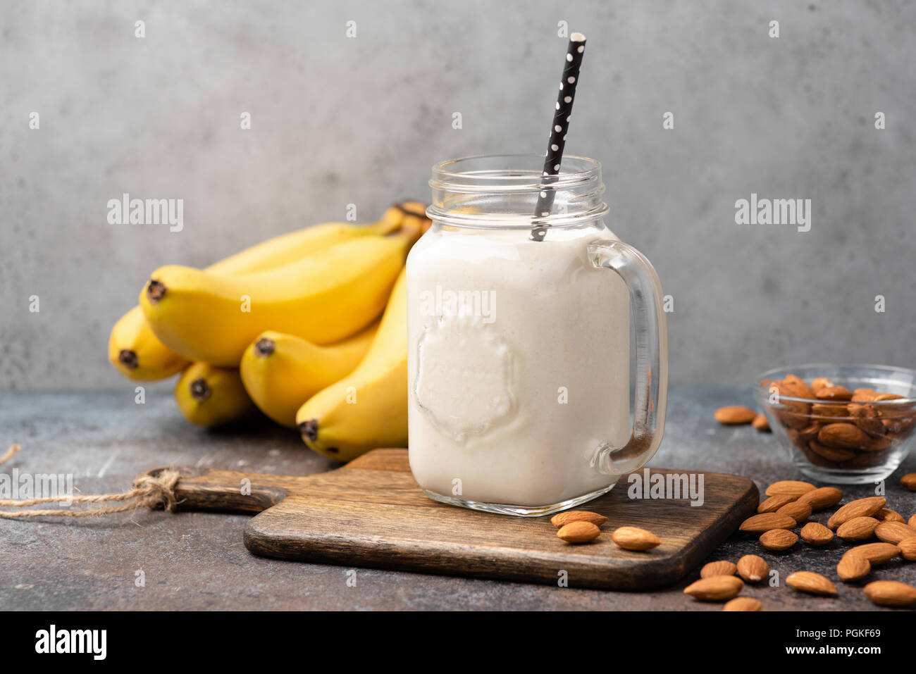 Banana frullato di proteina nel bicchiere sul legno scheda servente Foto Stock