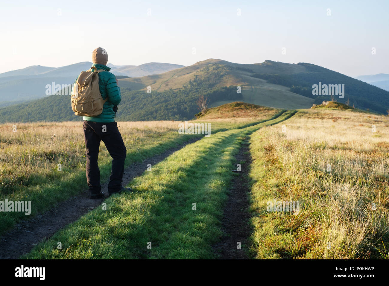 L uomo sulla strada delle montagne Foto Stock