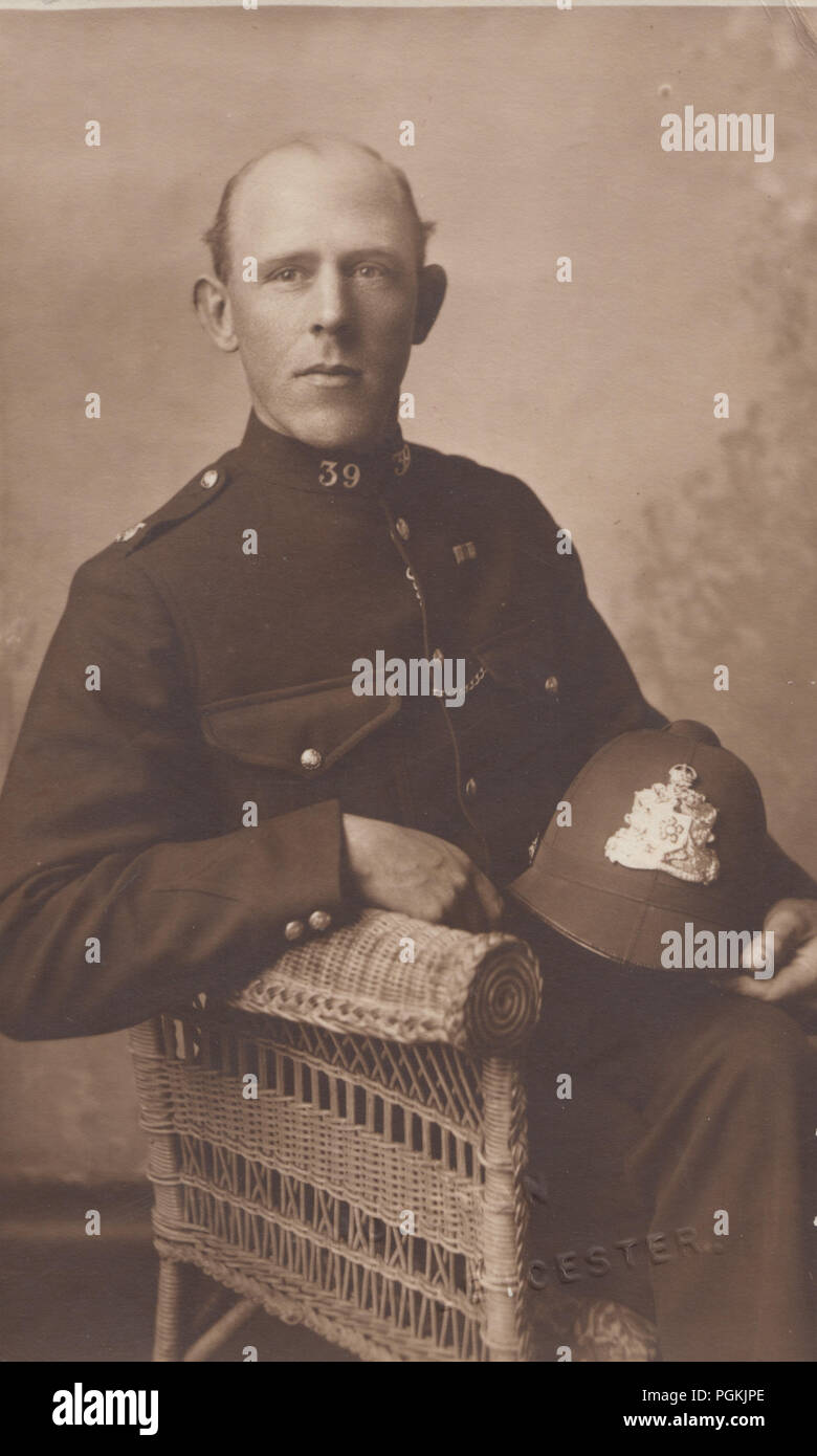 Vintage Leicester Fotografia di polizia Constable 39 seduto in una sedia tenendo la sua polizia casco Foto Stock