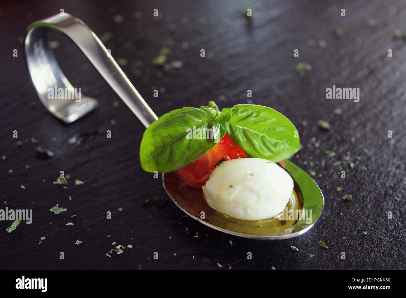 Antipasti con mozzarella e pomodoro sul cucchiaio - messa a fuoco selettiva Foto Stock