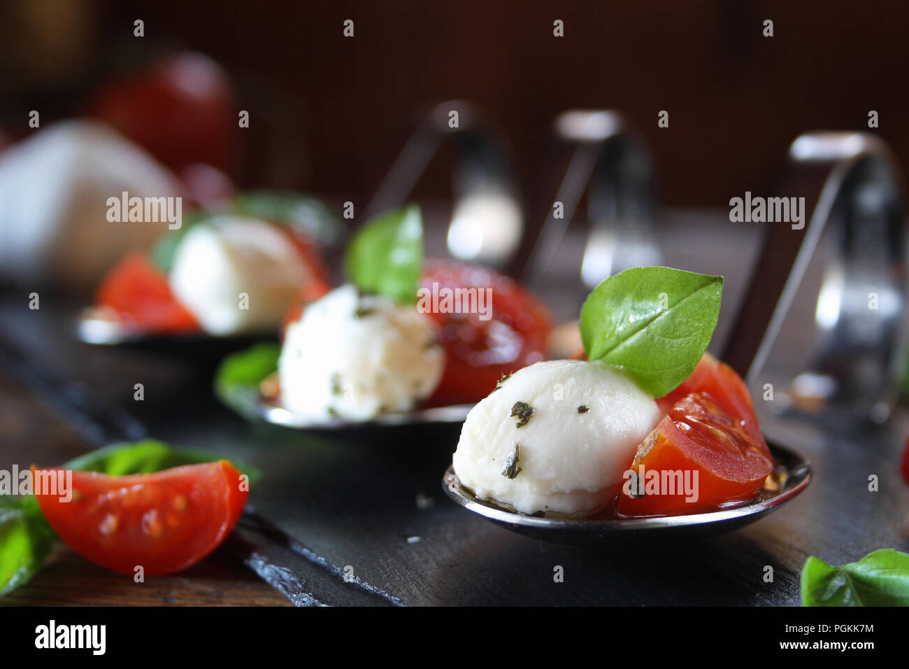 Antipasti con mozzarella e pomodoro sul cucchiaio - messa a fuoco selettiva Foto Stock