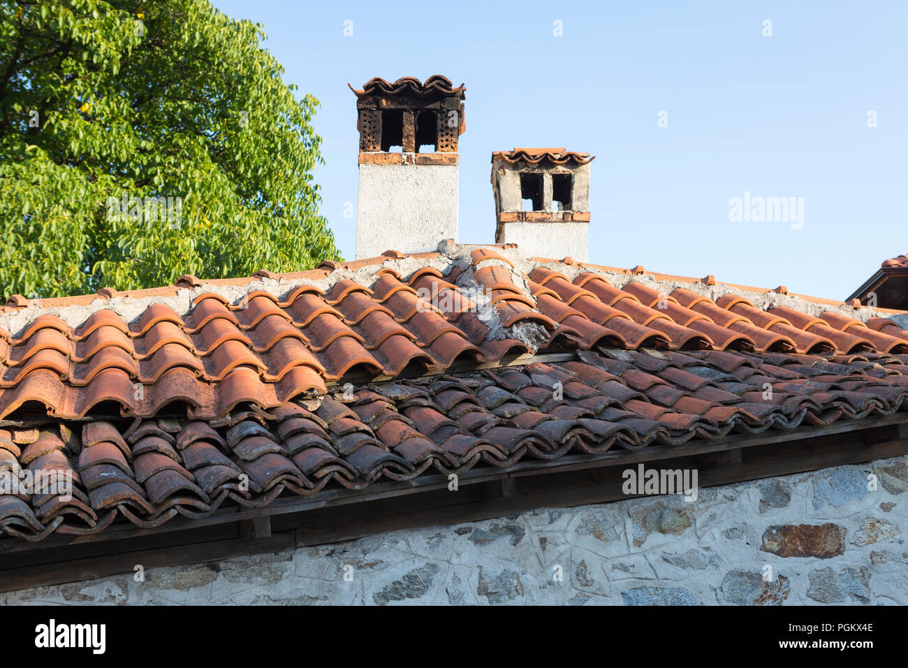 Tradizionale casa vecchia con tetti di tegole e un camino nella città vecchia di Koprivshitsa, Bulgaria Foto Stock