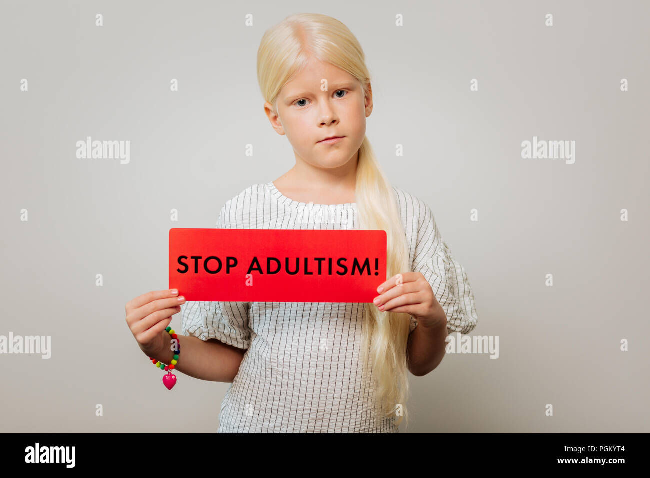 Grave ragazza con una tabella con uno slogan Foto Stock
