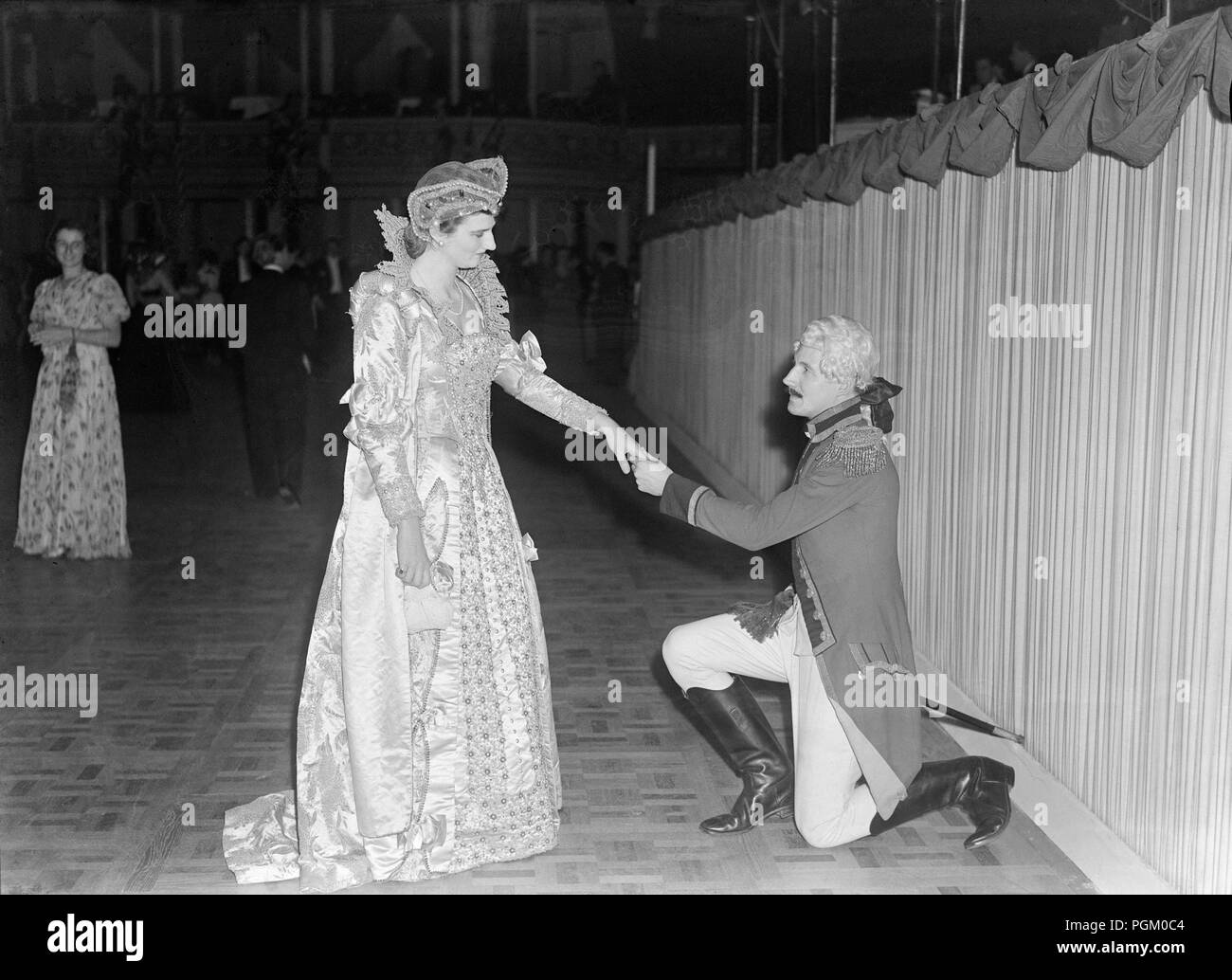 Il 28 settembre 1946. Cinque sfere delle Arti, il primo fondo scala fancy dress ball sin dalla fine della Seconda Guerra Mondiale, ha avuto luogo presso la Royal Albert Hall di Londra in aiuto del Royal Free Hospital. Miss Veneto Fawcus come la regina Elisabetta riceve il capitano Michael Turner-Bridger, come signore D'Arcy di sua maestà il piede protezioni. Foto Stock
